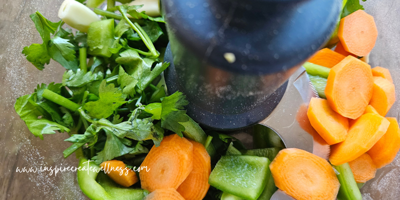 Roughly chopped carrots, cilantro, green peppers, and garlic in food processor.