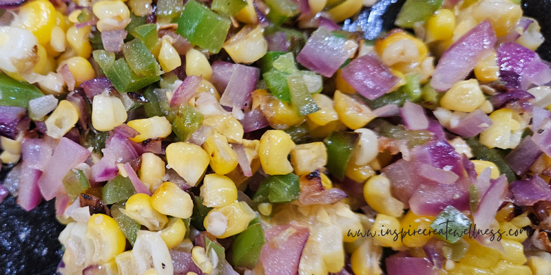 Red onion, jalapeno, and frozen corn sauteed in frying pan