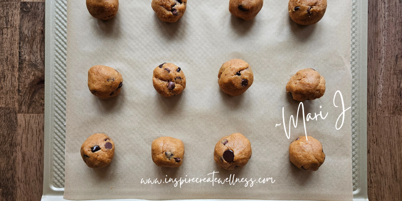 12 cookie dough balls on a cookie sheet