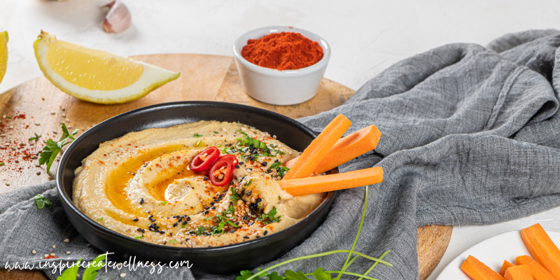 Hummus in a bowl with cut up vegetables