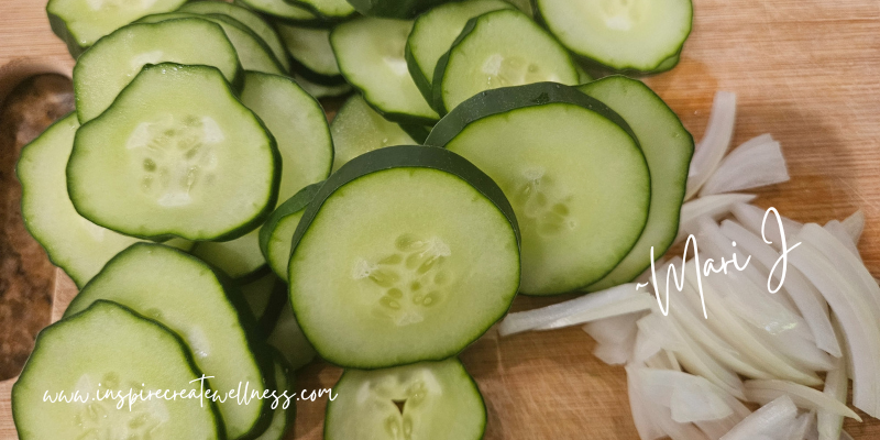 Refrigerator Pickle Recipe -Sliced cucumber and onions on a cutting board