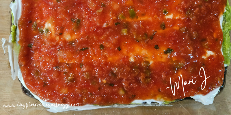 Salsa spread on top of sour cream, guacamole, and black refried beans for an easy dip