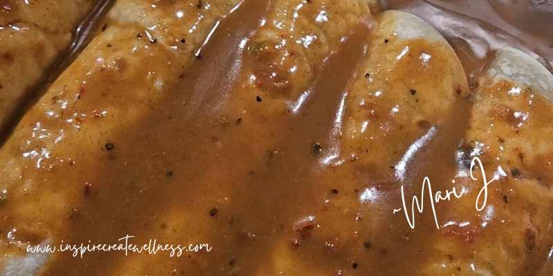 Homemade enchilada sauce poured over flour shells