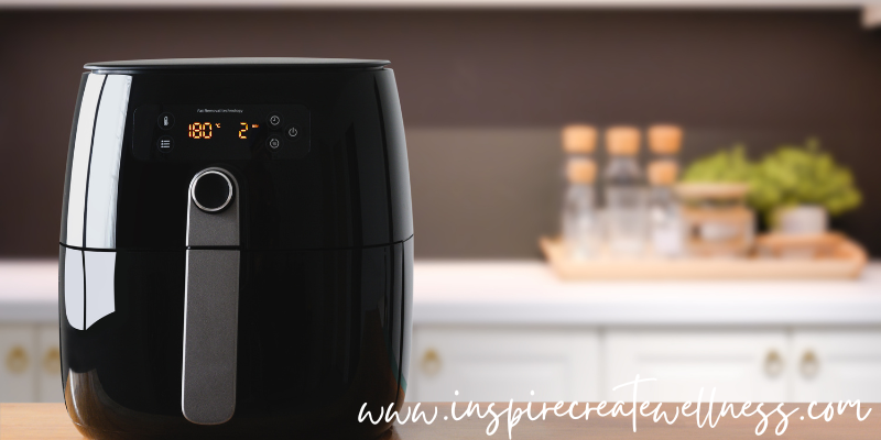 Black air fryer with basket on the kitchen counter