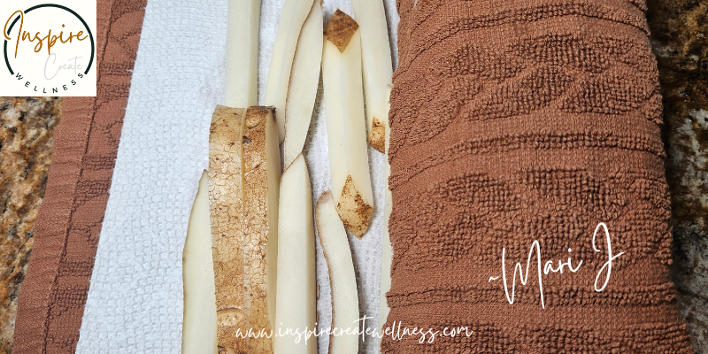 Naturally cut russet potato fries laid out on a kitchen towel to dry