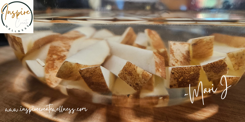 Glass bowl full of naturally cut potato fries soaking in filtered water.