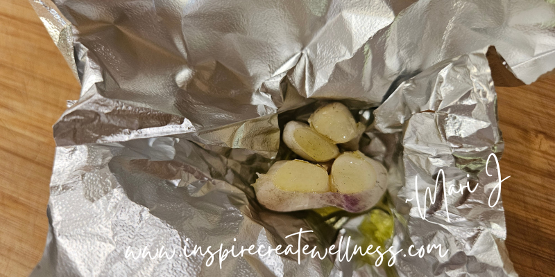 Four cloves of garlic with olive oil, wrapped in foil for roasting