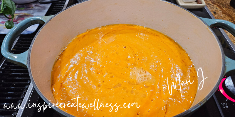 Blended roasted tomatoes, onions, and garlic poured into a dutch oven for tomato soup