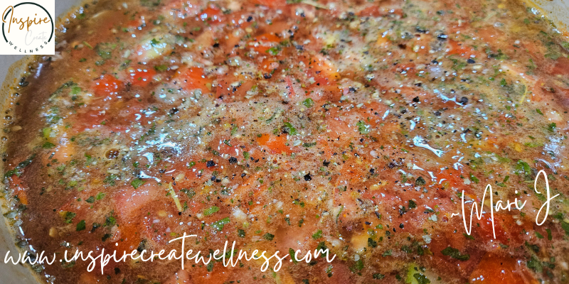 Tomatoes, onions celery, carrots, and herbs simmering in a dutch oven for hearty homemade minestrone soup