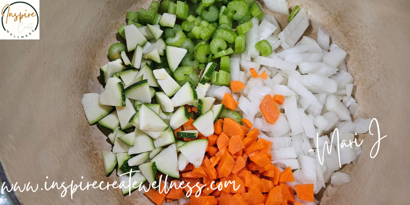 Chopped garden zucchini, celery, carrots, and onions in a dutch oven.