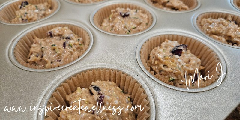 Zucchini muffin batter in a muffin tray before baking