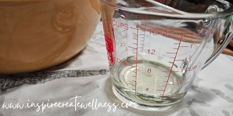 Melted Organic Coconut Oil in a measuring cup for Delicious Homemade Biscuits