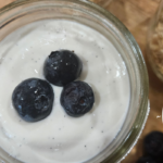 Healthy Cheesecake in a jar with 3 blueberries on top