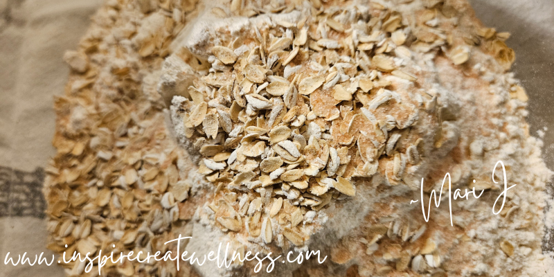 Flour and organic oats in a large glass bowl for Easy Honey Oat Bread